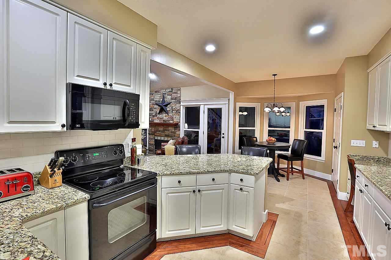 8536 Yucca Trail Raleigh, NC 27615 - Photo 4 of 23 a kitchen with stainless steel appliances granite countertop a stove and cabinets