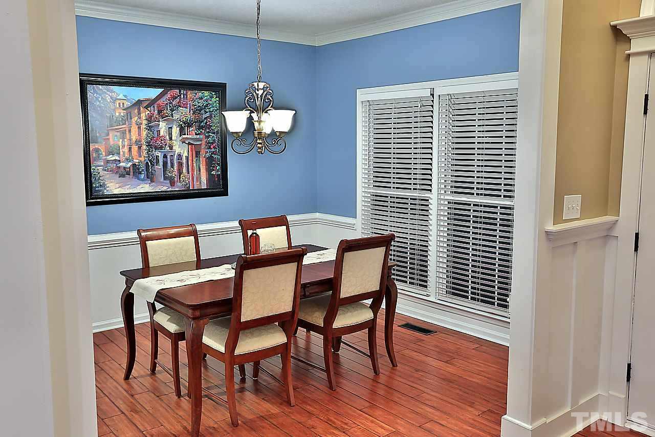 8536 Yucca Trail Raleigh, NC 27615 - Photo 8 of 23 a view of a dining room with furniture and wooden floor