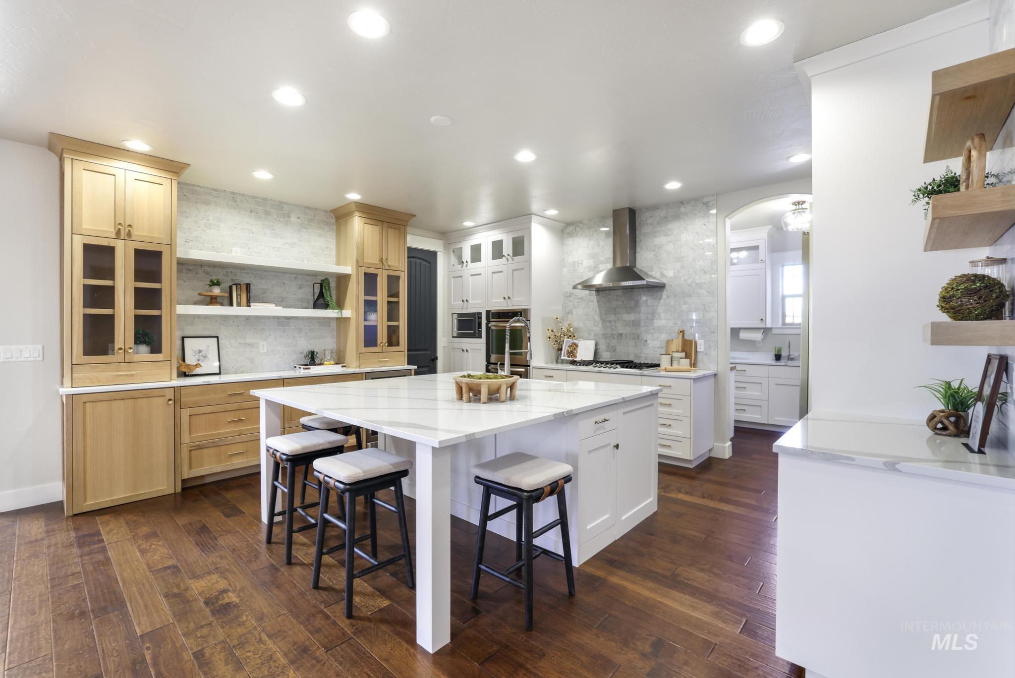 3365 Willow Way Twin Falls, ID 83301 - Photo 12 of 50 Kitchen featuring open shelves, light stone countertops, arched walkways, a breakfast bar, and dark wood-style floors