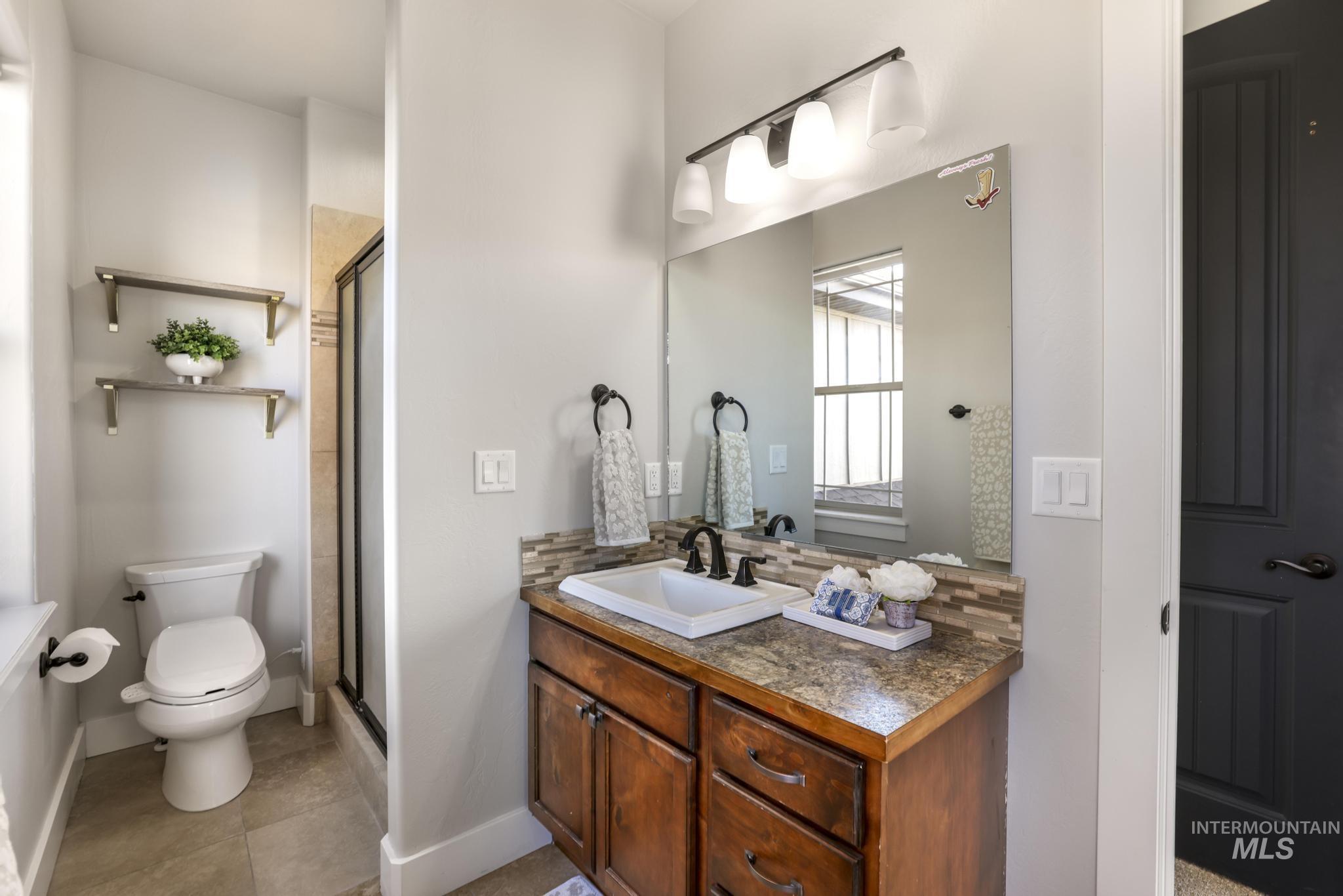 3365 Willow Way Twin Falls, ID 83301 - Photo 28 of 50 Full bathroom featuring vanity, a stall shower, light tile patterned floors, and decorative backsplash