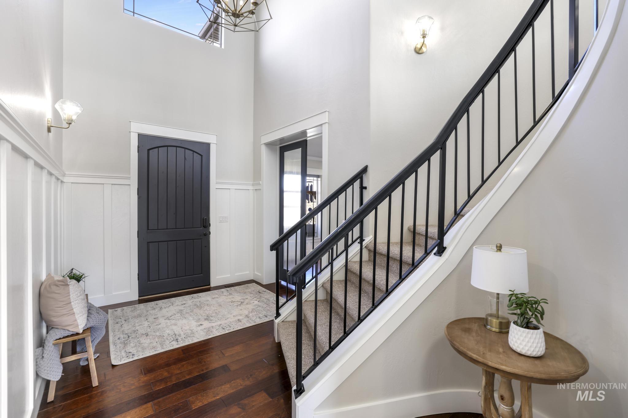 3365 Willow Way Twin Falls, ID 83301 - Photo 8 of 50 Entryway with a decorative wall, dark wood-type flooring, wainscoting, a high ceiling, and hanging lights