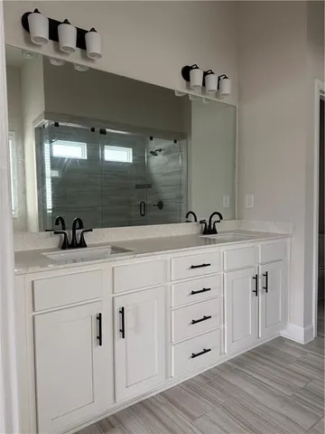 a bathroom with a double vanity sink and mirror