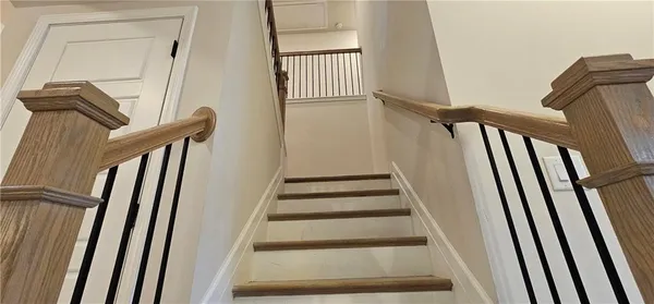 a view of staircase with railing and white walls