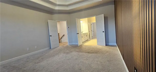 a view of an empty room with closet and a bathroom