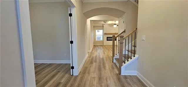 a view of a hallway with wooden floor and stairs