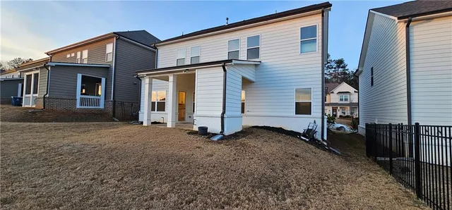 a view of a house with backyard and wooden fence