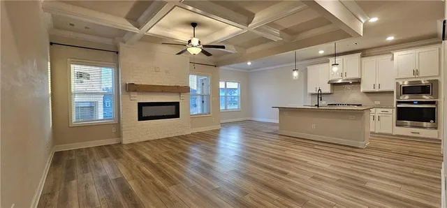 a view of kitchen with granite countertop cabinets stainless steel appliances and a fireplace