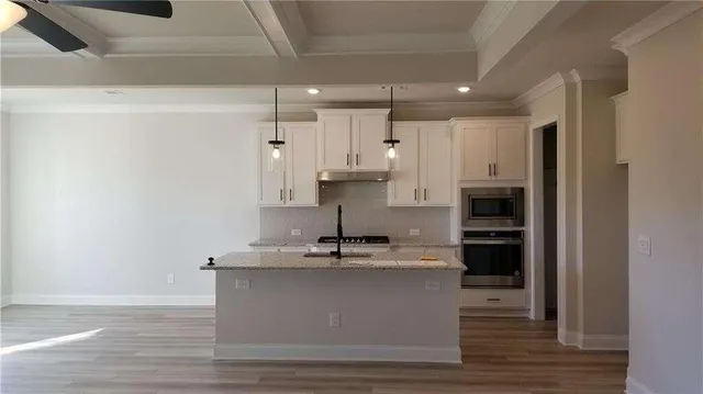 a view of kitchen with stainless steel appliances granite countertop refrigerator sink and cabinets