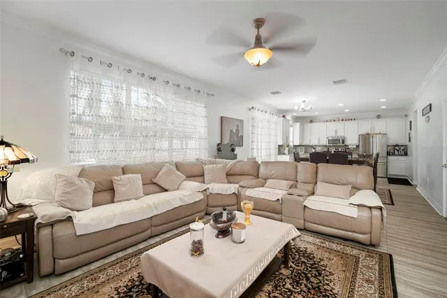 a living room with furniture kitchen view and a window