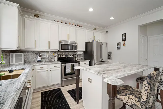 a kitchen with kitchen island a stove a sink and a refrigerator