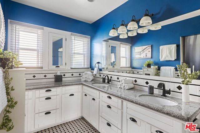 a kitchen with kitchen island granite countertop a sink a window and a counter space