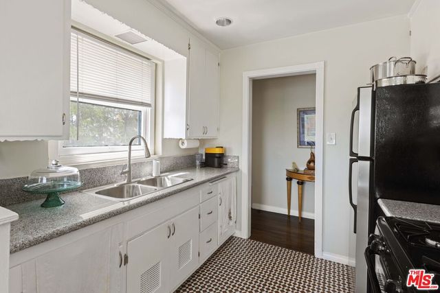 a kitchen with granite countertop a sink stainless steel appliances and cabinets