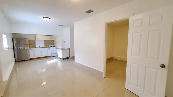 a view of a kitchen with a sink and an empty room