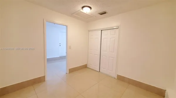 an empty room with closet and a bathroom