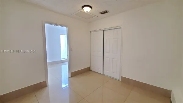 an empty room with closet and a chandelier fan