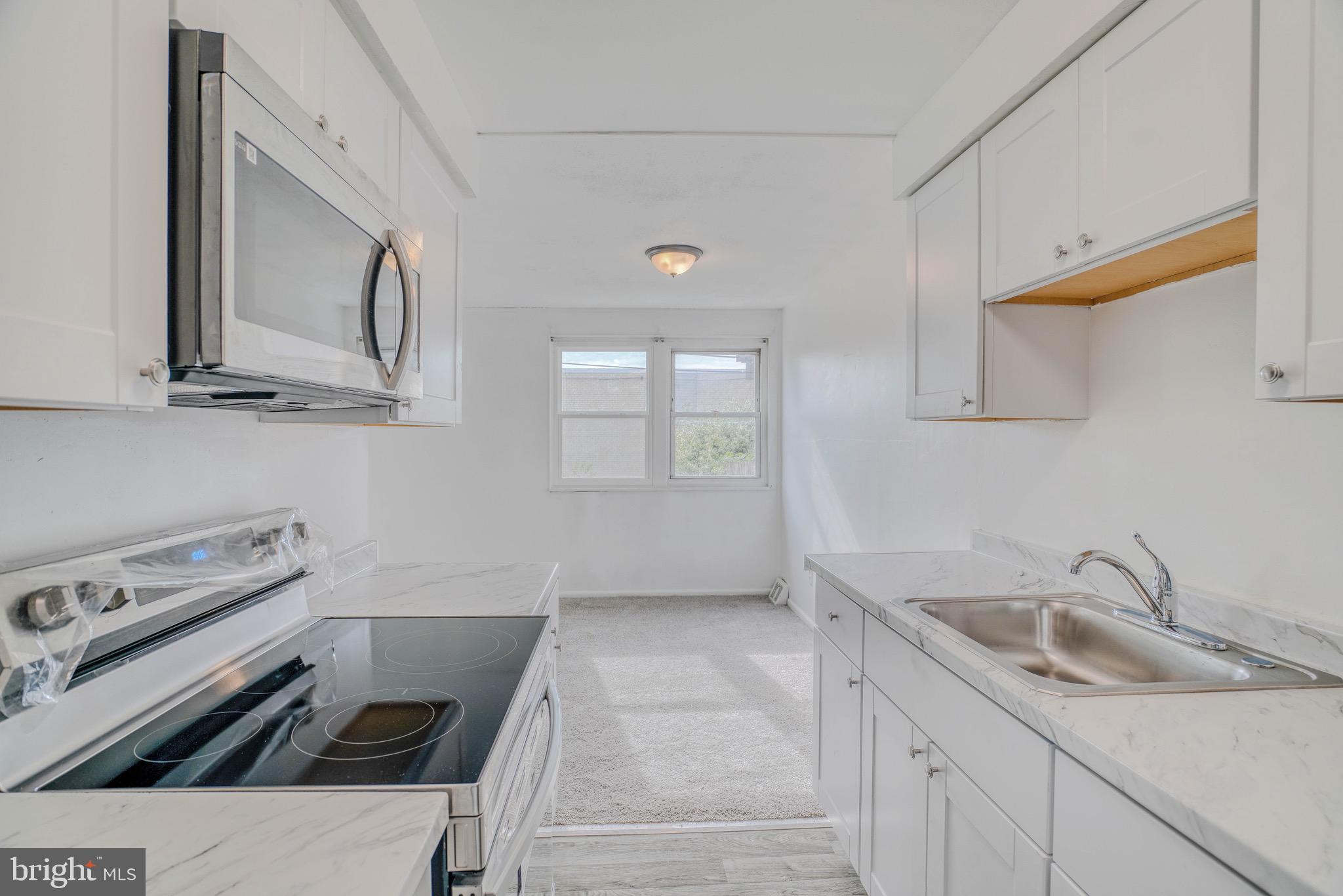 10203 East Keswick Road, Unit 1 Philadelphia, PA 19114 - Photo 11 of 23 a kitchen with a sink stove and cabinets