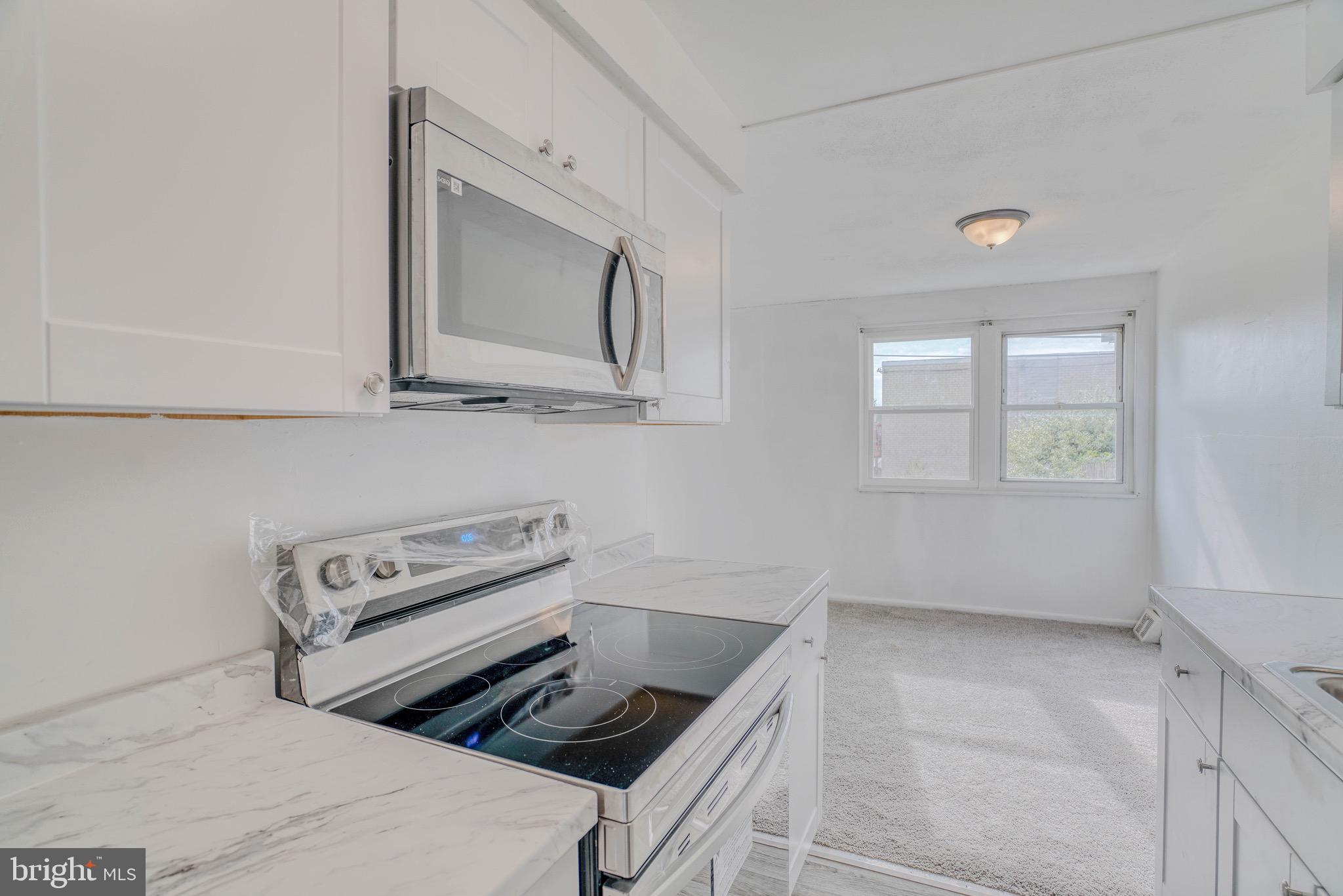 10203 East Keswick Road, Unit 1 Philadelphia, PA 19114 - Photo 12 of 23 a kitchen with a stove and a microwave