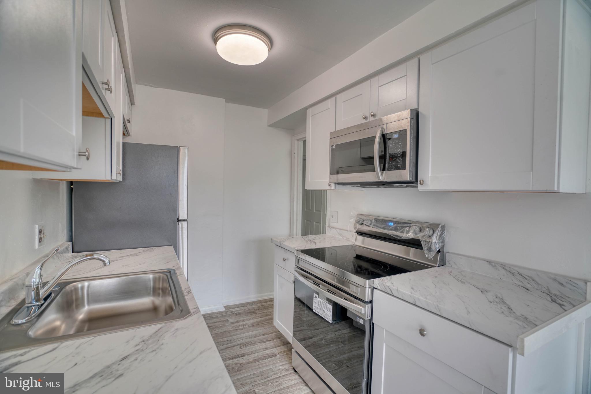 10203 East Keswick Road, Unit 1 Philadelphia, PA 19114 - Photo 8 of 23 a kitchen that has a sink and a stove