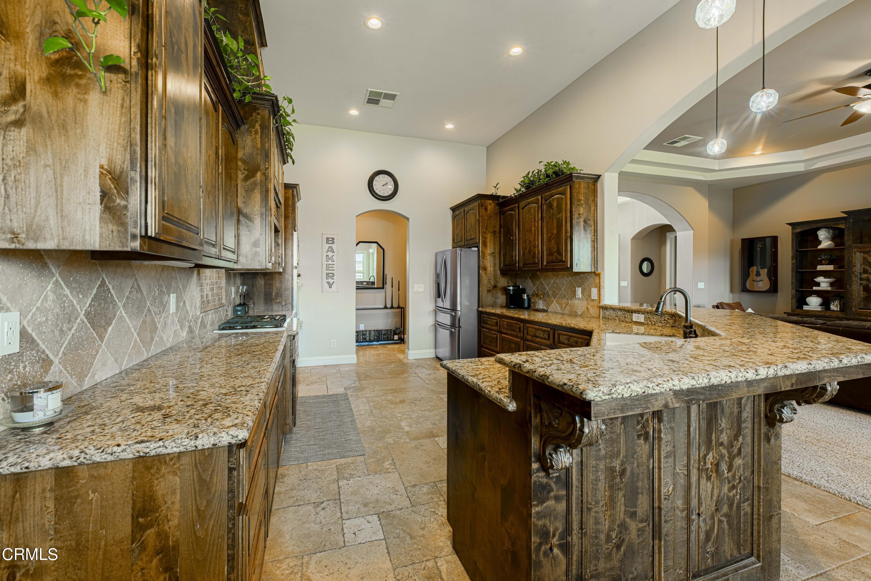 15023 Redwood Pass Drive Bakersfield, CA 93314 - Photo 18 of 67 a kitchen with stainless steel appliances granite countertop a sink and a refrigerator