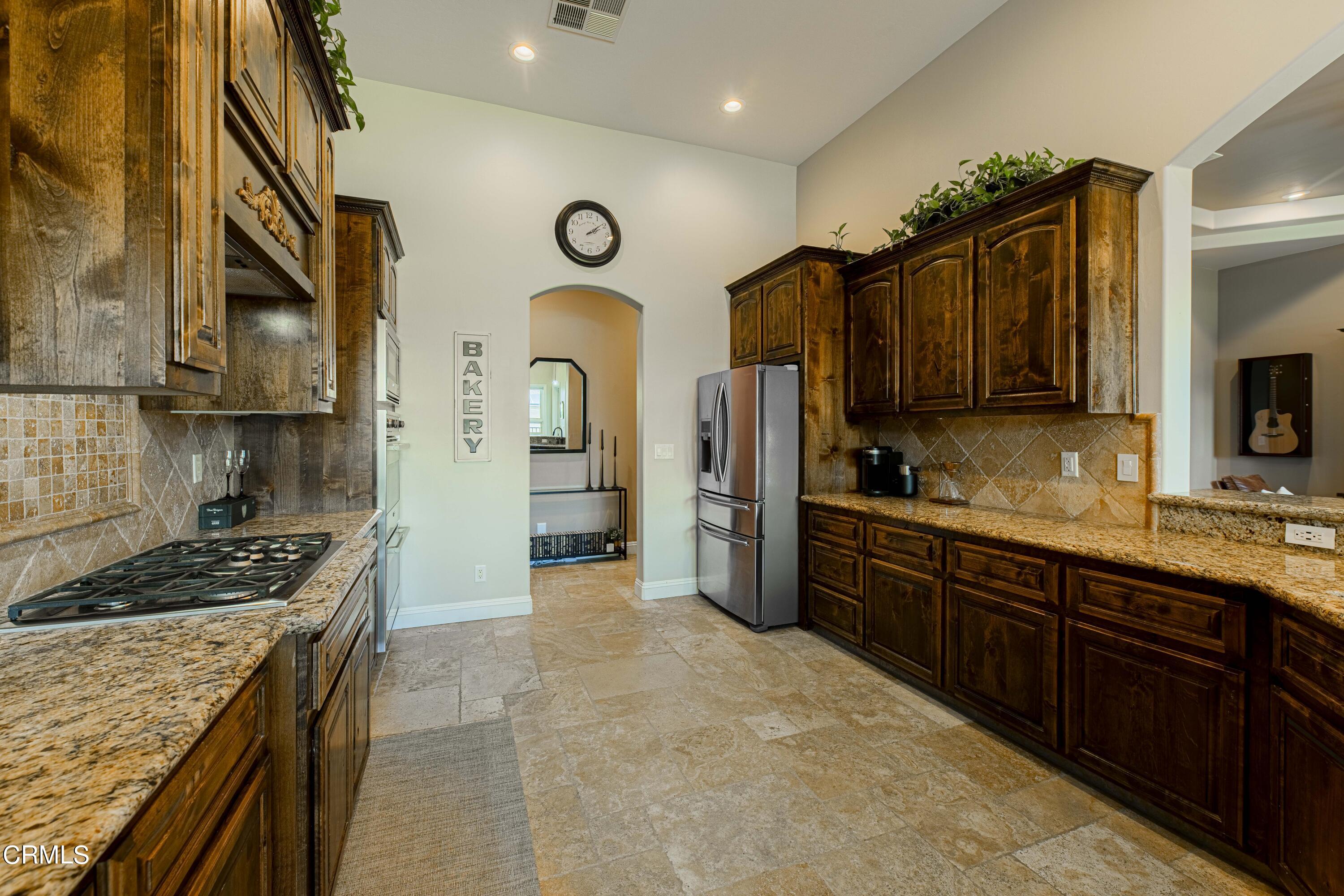15023 Redwood Pass Drive Bakersfield, CA 93314 - Photo 19 of 67 a kitchen with stainless steel appliances granite countertop a stove refrigerator sink and cabinets