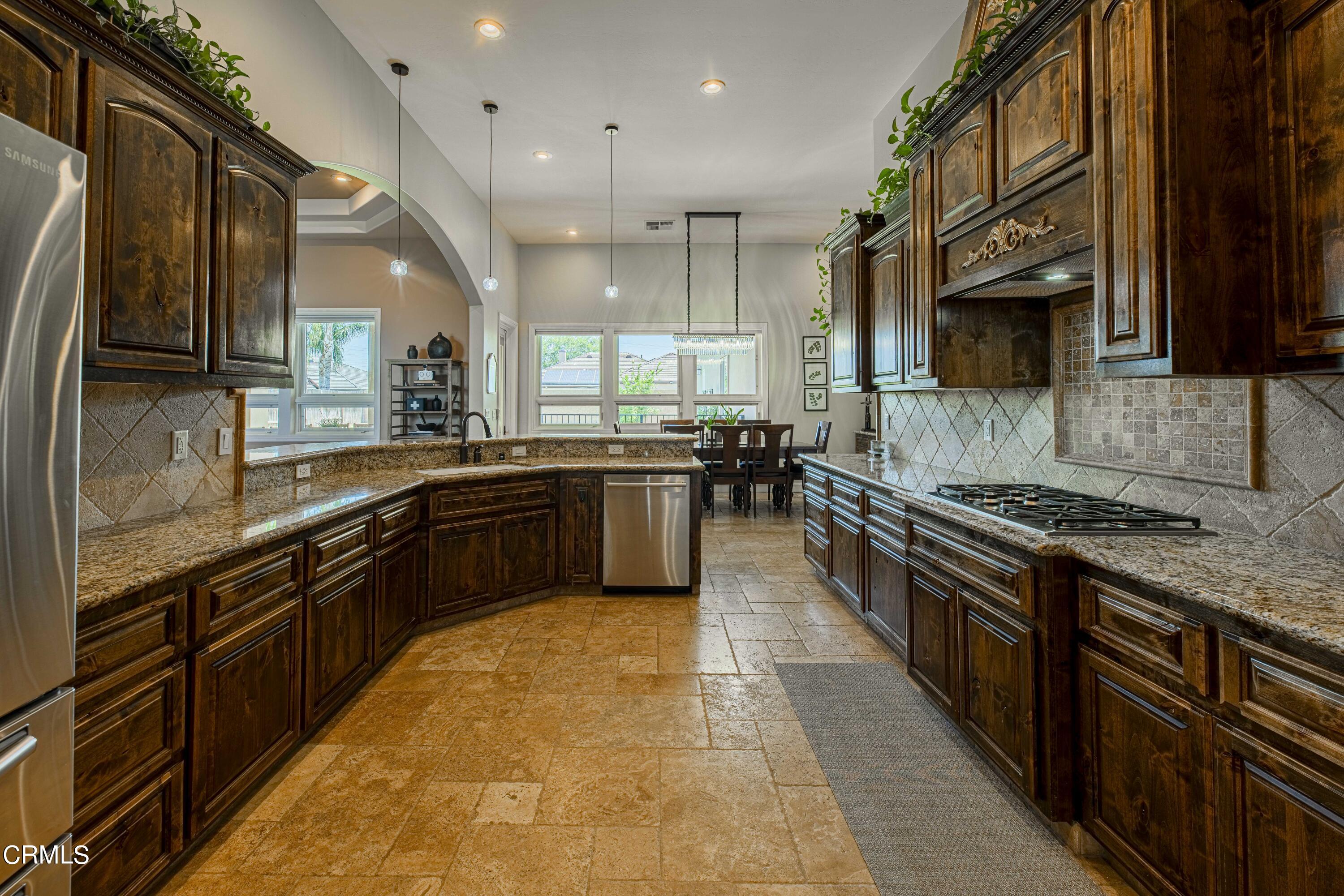 15023 Redwood Pass Drive Bakersfield, CA 93314 - Photo 20 of 67 a large kitchen with stainless steel appliances granite countertop wooden cabinets a sink dishwasher a stove and a refrigerator