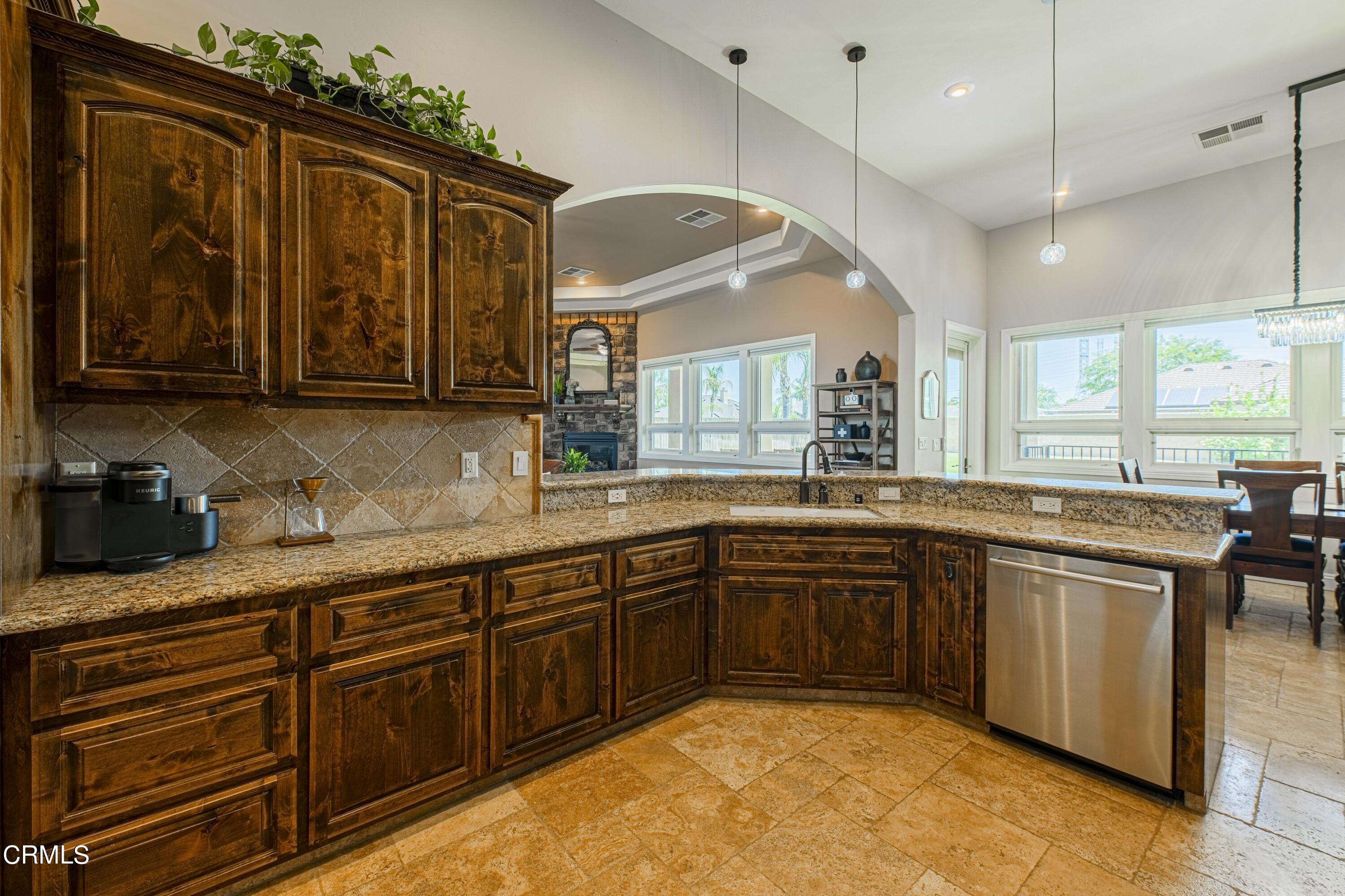 15023 Redwood Pass Drive Bakersfield, CA 93314 - Photo 21 of 67 a large kitchen with kitchen island granite countertop a sink and dishwasher wooden cabinets with a large window