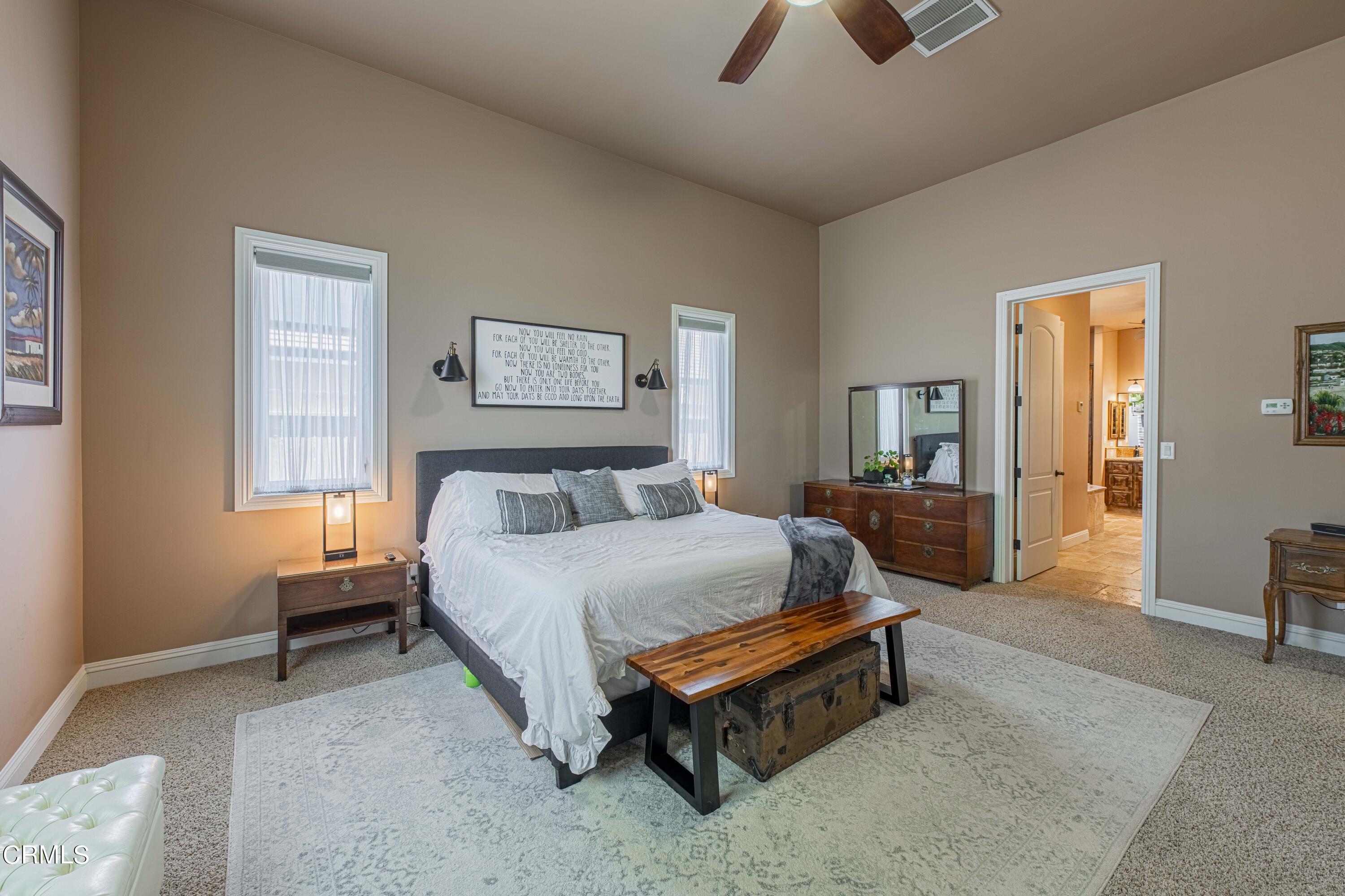15023 Redwood Pass Drive Bakersfield, CA 93314 - Photo 23 of 67 a spacious bedroom with a bed and a chandelier