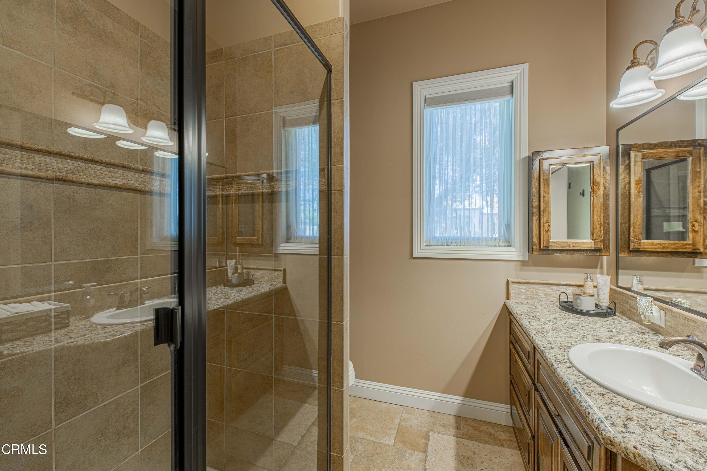 15023 Redwood Pass Drive Bakersfield, CA 93314 - Photo 32 of 67 a bathroom with a granite countertop shower mirror and a sink