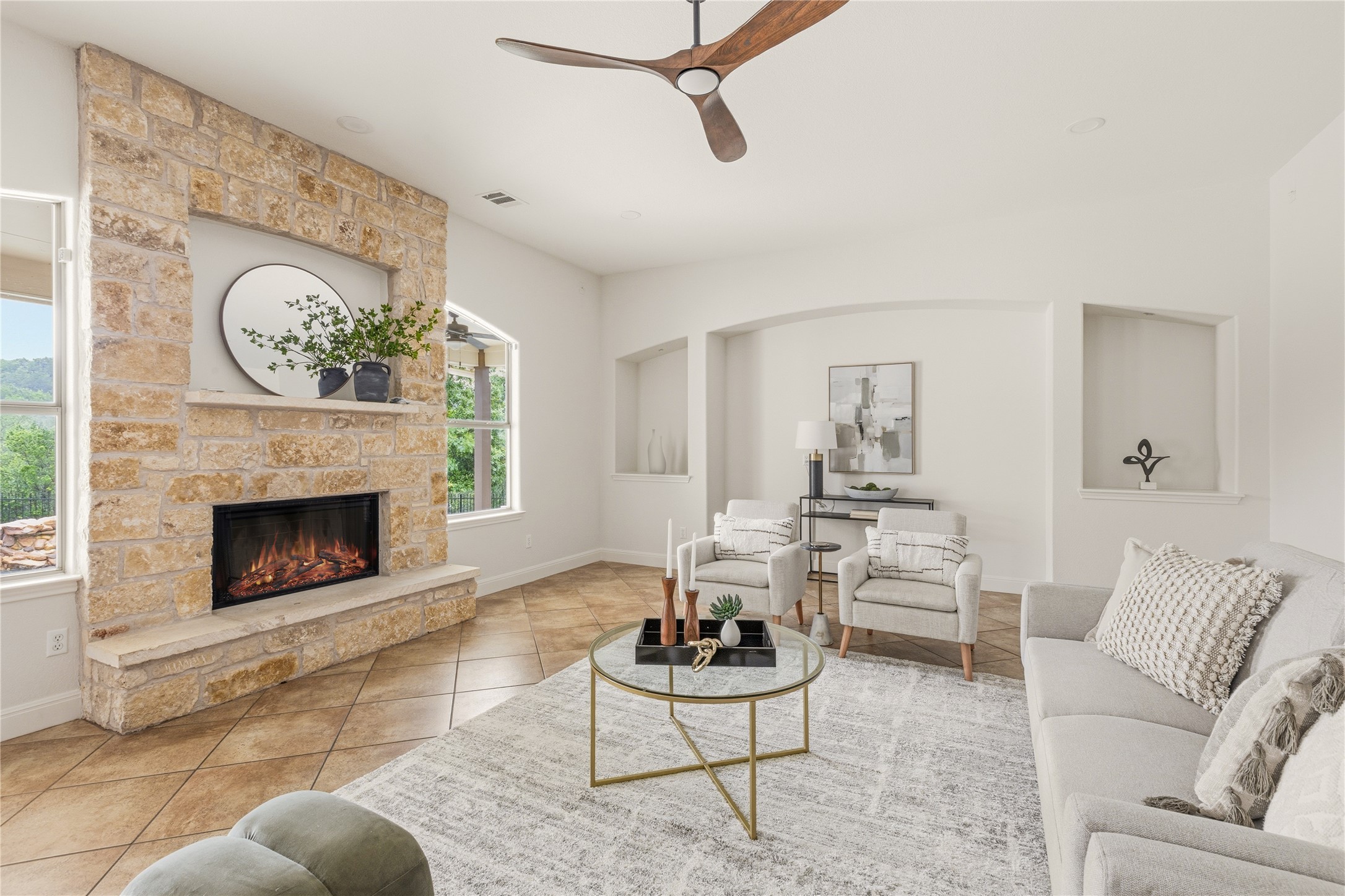 1432 Tom Sawyer Road Austin, TX 78737 - Photo 10 of 33 A striking stone fireplace anchors this well-lit living area, featuring an open-concept layout.
