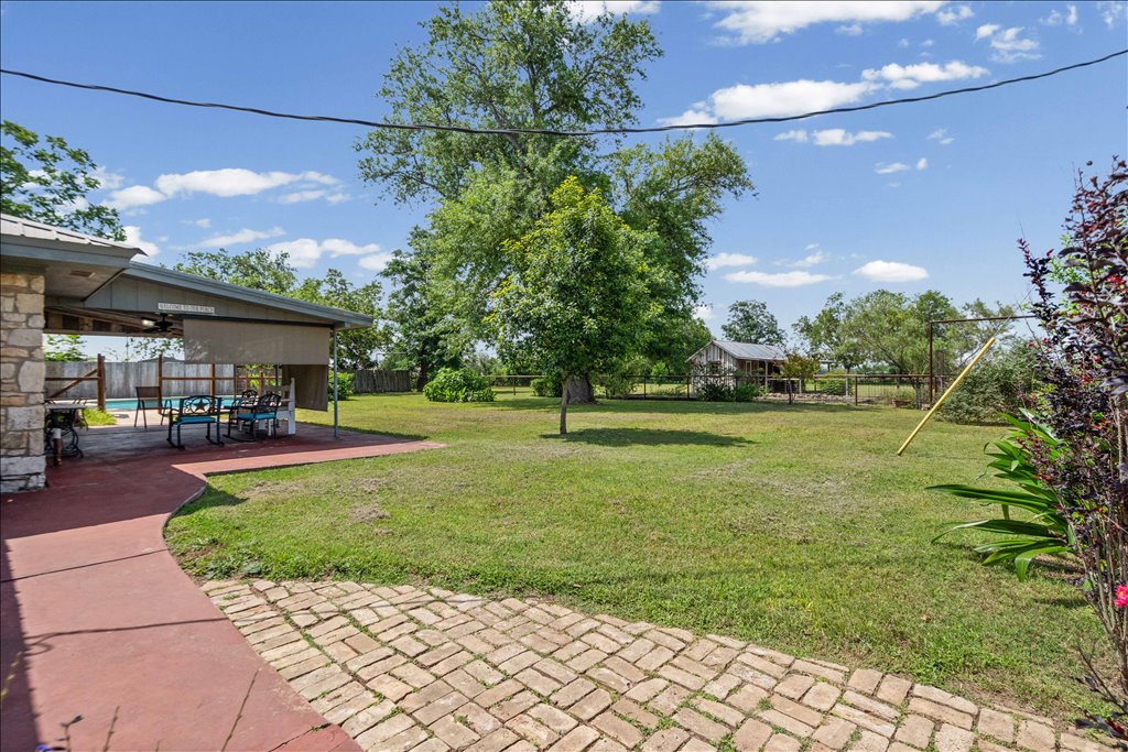 2421 Post Oak Road Webberville, TX 78653 - Photo 24 of 36 Let’s head out back because this yard is spectacular. You’ve got a massive, manicured lawn that’s fully fenced in, surrounded by gorgeous mature shade trees.