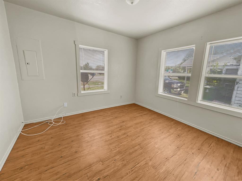 109 South 5th Street Sanger, TX 76266 - Photo 11 of 14 a view of an empty room with a window and wooden floor