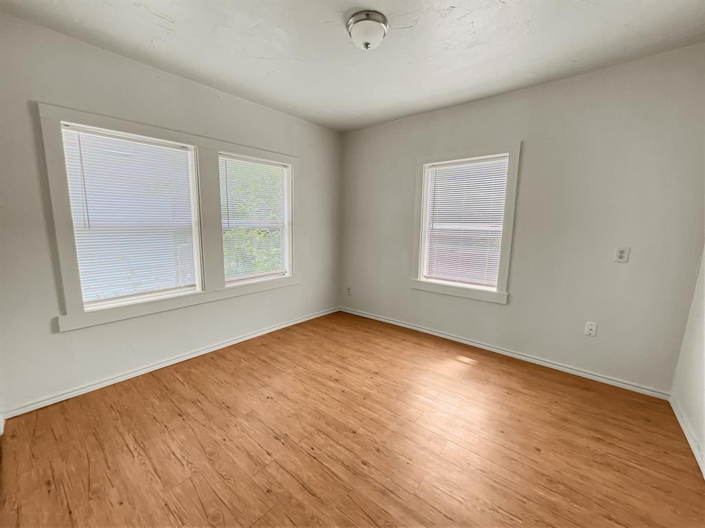 109 South 5th Street Sanger, TX 76266 - Photo 12 of 14 a view of an empty room with wooden floor and a window
