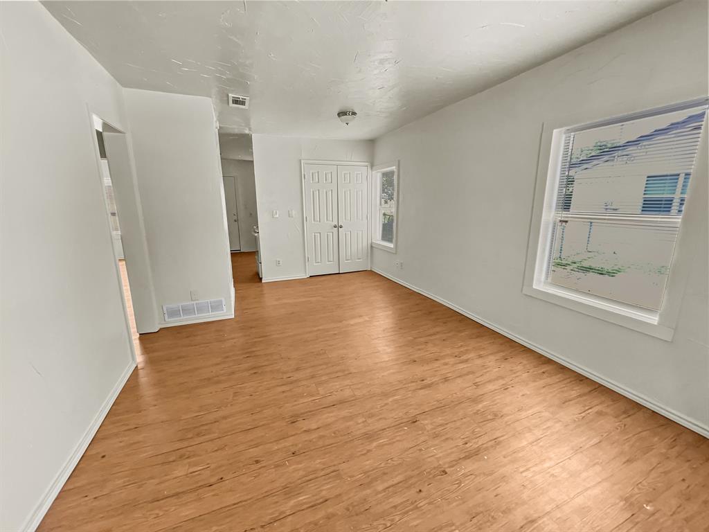 109 South 5th Street Sanger, TX 76266 - Photo 7 of 14 a view of an empty room with wooden floor and a window