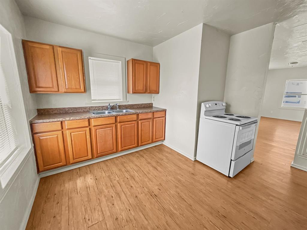 109 South 5th Street Sanger, TX 76266 - Photo 10 of 14 a kitchen with stainless steel appliances granite countertop a stove a sink and a microwave