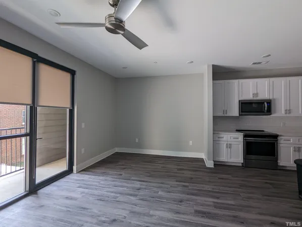 wooden floor in an empty room with a kitchen