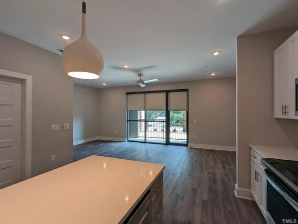 an open kitchen with wooden floor and a large window