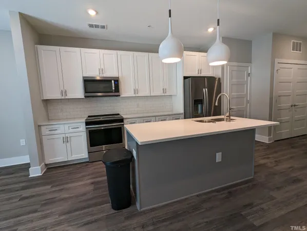 a kitchen with a sink cabinets and wooden floor