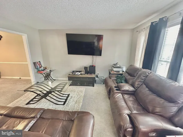 a living room with furniture a flat screen tv and a window