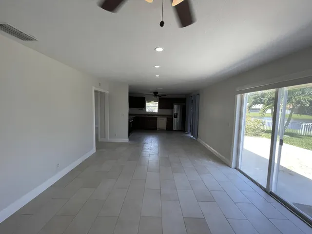 an empty room with windows and view of an empty room