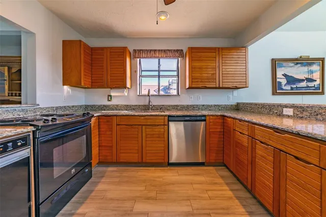 a kitchen with stainless steel appliances granite countertop a stove sink and cabinets