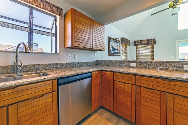 a kitchen with granite countertop a sink and a window