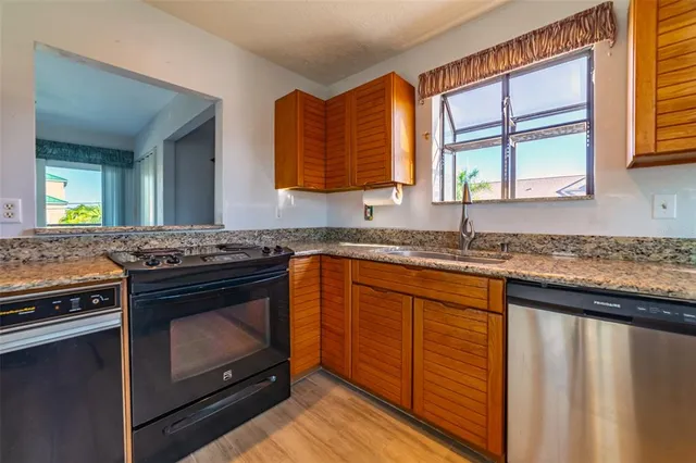 a kitchen with stainless steel appliances granite countertop a stove a sink and a microwave
