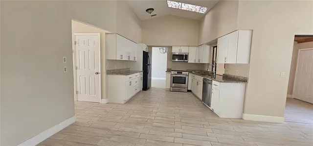 a view of a kitchen with a sink and refrigerator