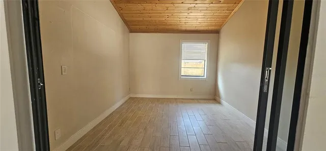 a view of hallway with window and wooden floor