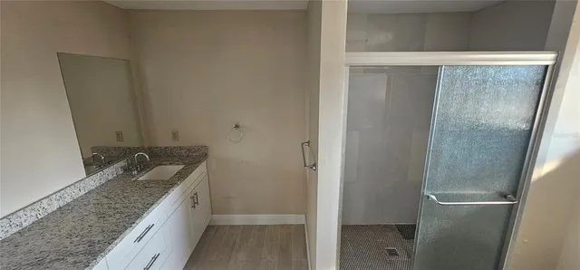 a bathroom with a granite countertop shower and a sink