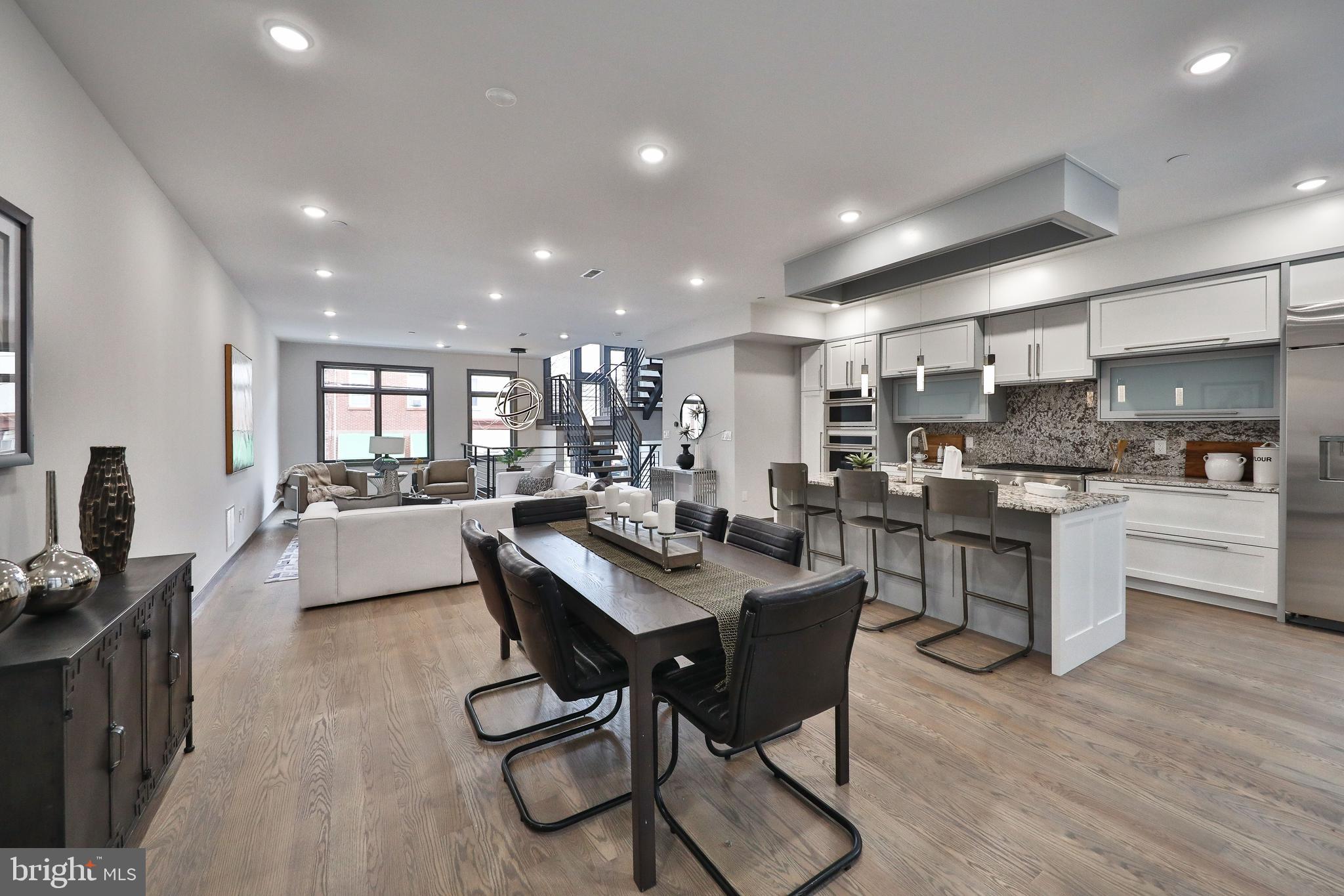 1024 Christian Street Philadelphia, PA 19147 - Photo 14 of 44 a kitchen with stainless steel appliances kitchen island granite countertop a dining table chairs stove and white cabinets