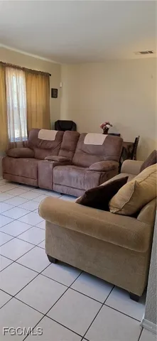 a living room with couches and large window with rug