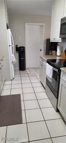 a kitchen with granite countertop a refrigerator and a stove top oven