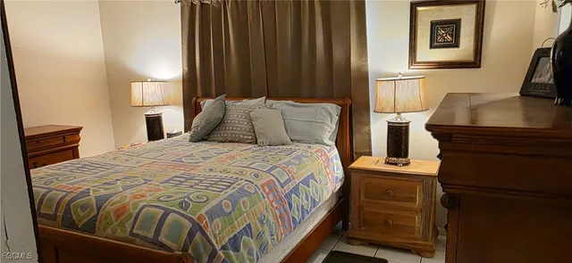 a bedroom with a bed and a flat tv screen on a dresser