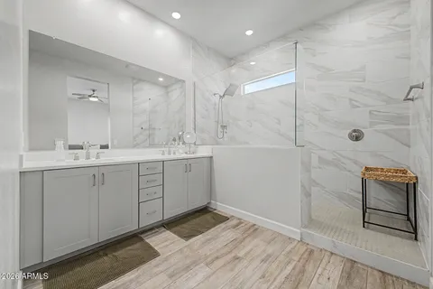 a spacious bathroom with a shower sink and mirror